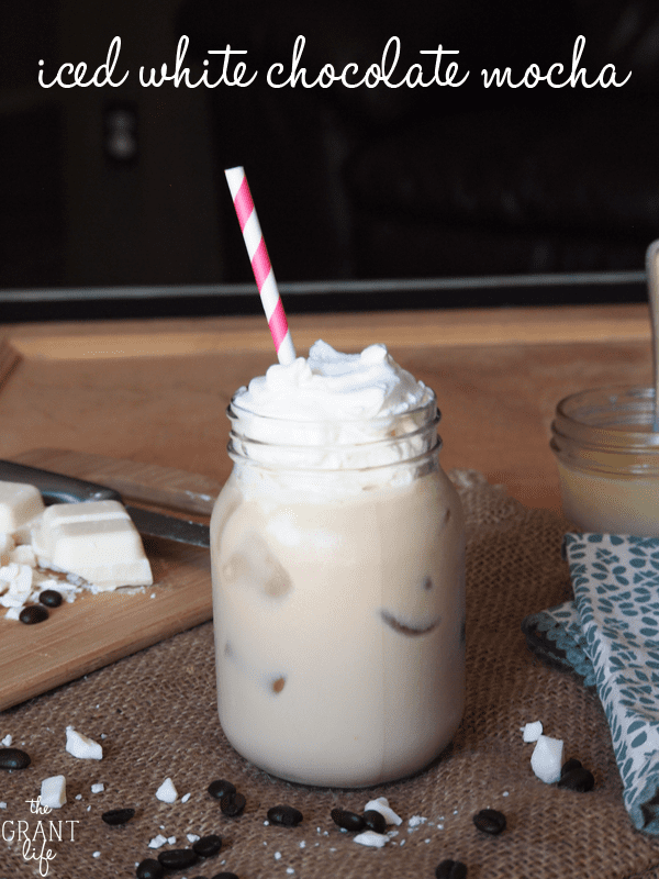 An iced white chocolate mocha in a glass mason jar topped with whipped cream