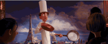 Linguine from the Pixar movie Ratatouille holding up frying pans while cameras flash