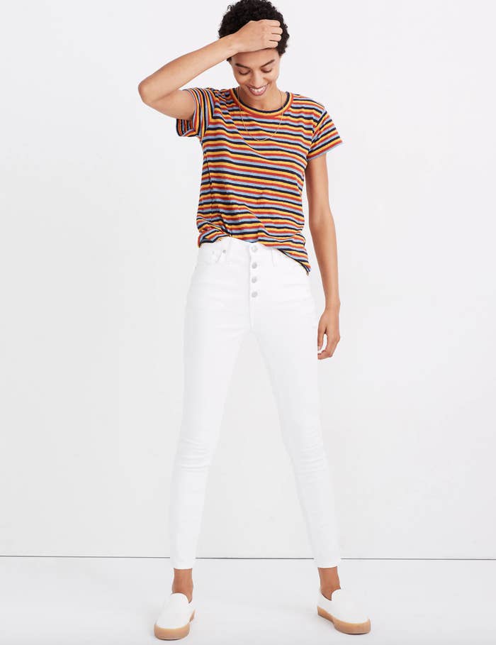 A model in a t-shirt with navy blue, yellow, red, and light blue stripes 