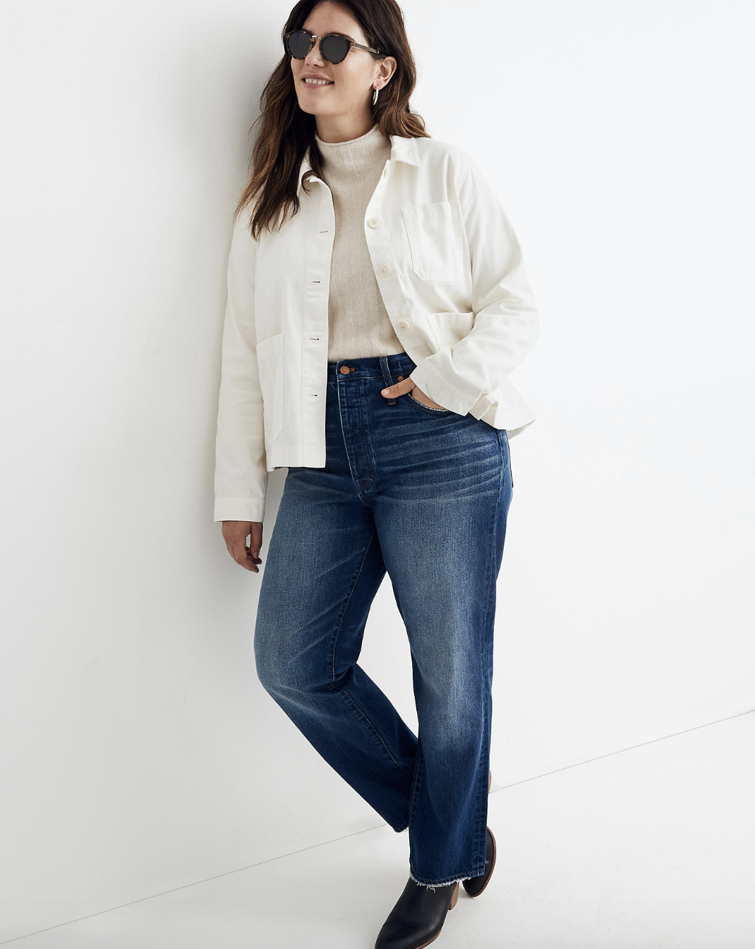 A model in a white button up collared denim jacket 
