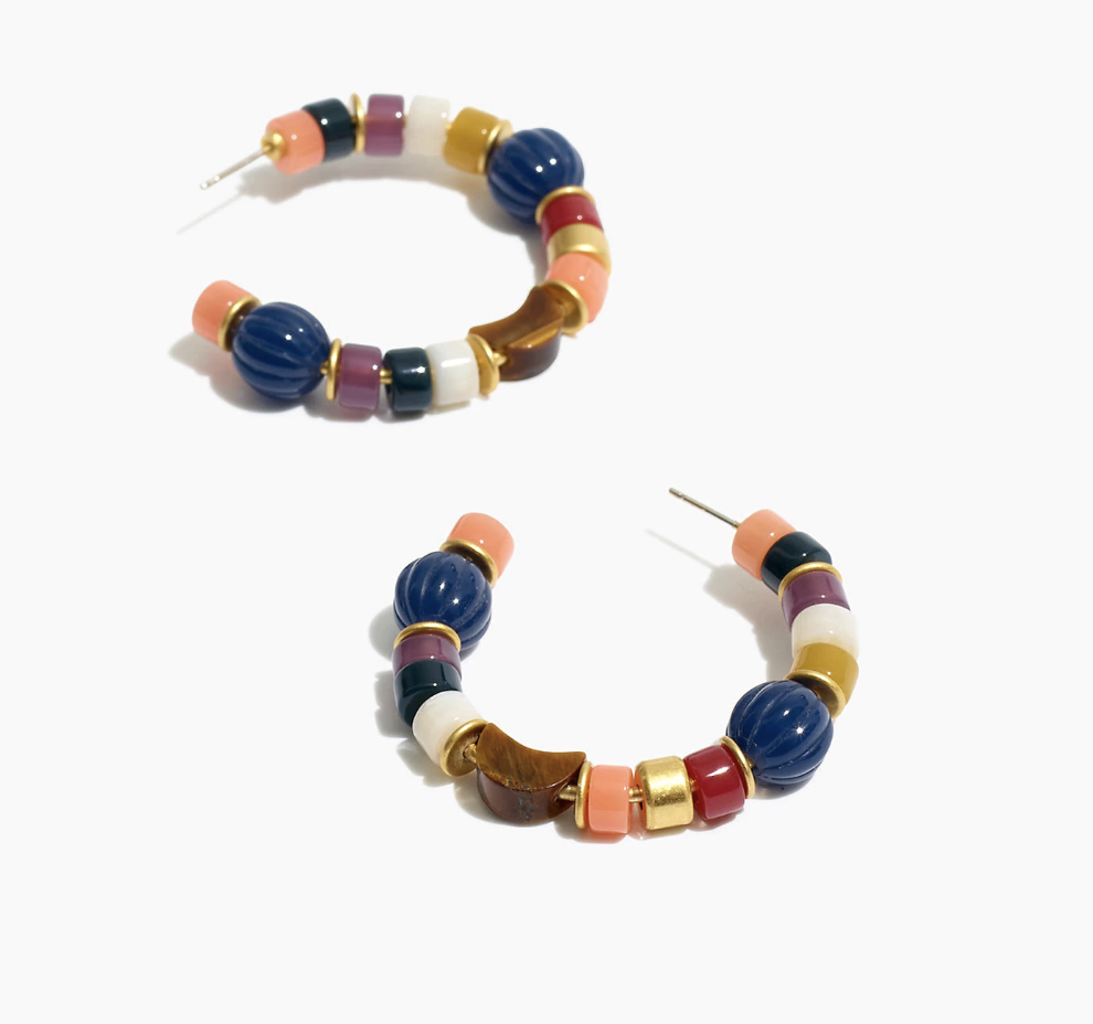 A pair of hoop earrings with multiple colors and shapes of beads 