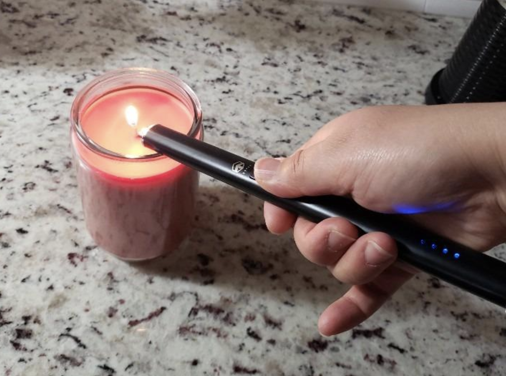 A reviewer using the lighter to light a candle 
