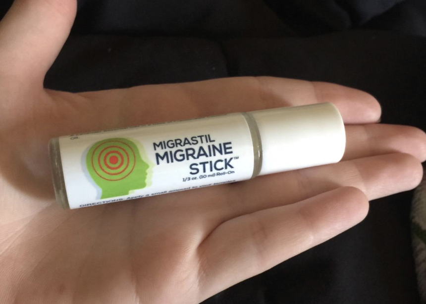 A reviewer holding the migraine stick 