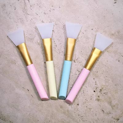 Four silicone mask brushes on a surface 
