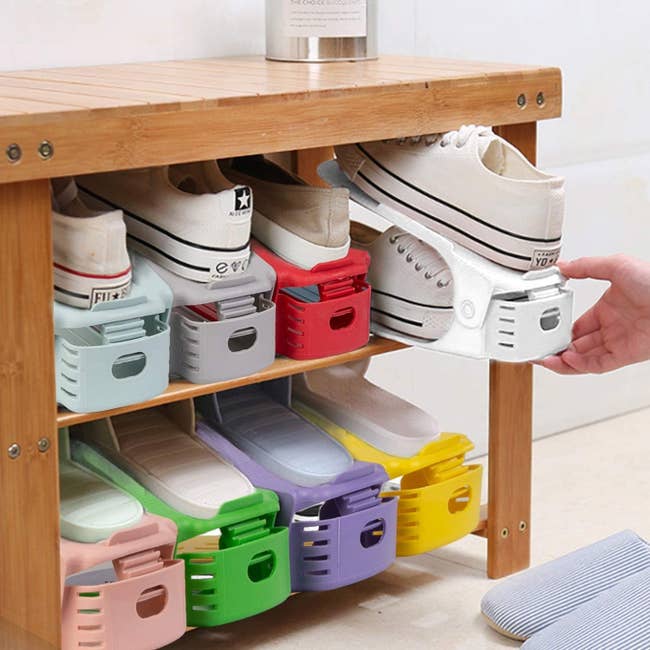 colorful shoe organisers that stack shoes on top of each other so each pair is the width of one pair 