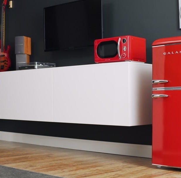 a small, red freezer and fridge with a retro look to it