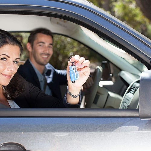 Two models in a car with one of them holding the key chian
