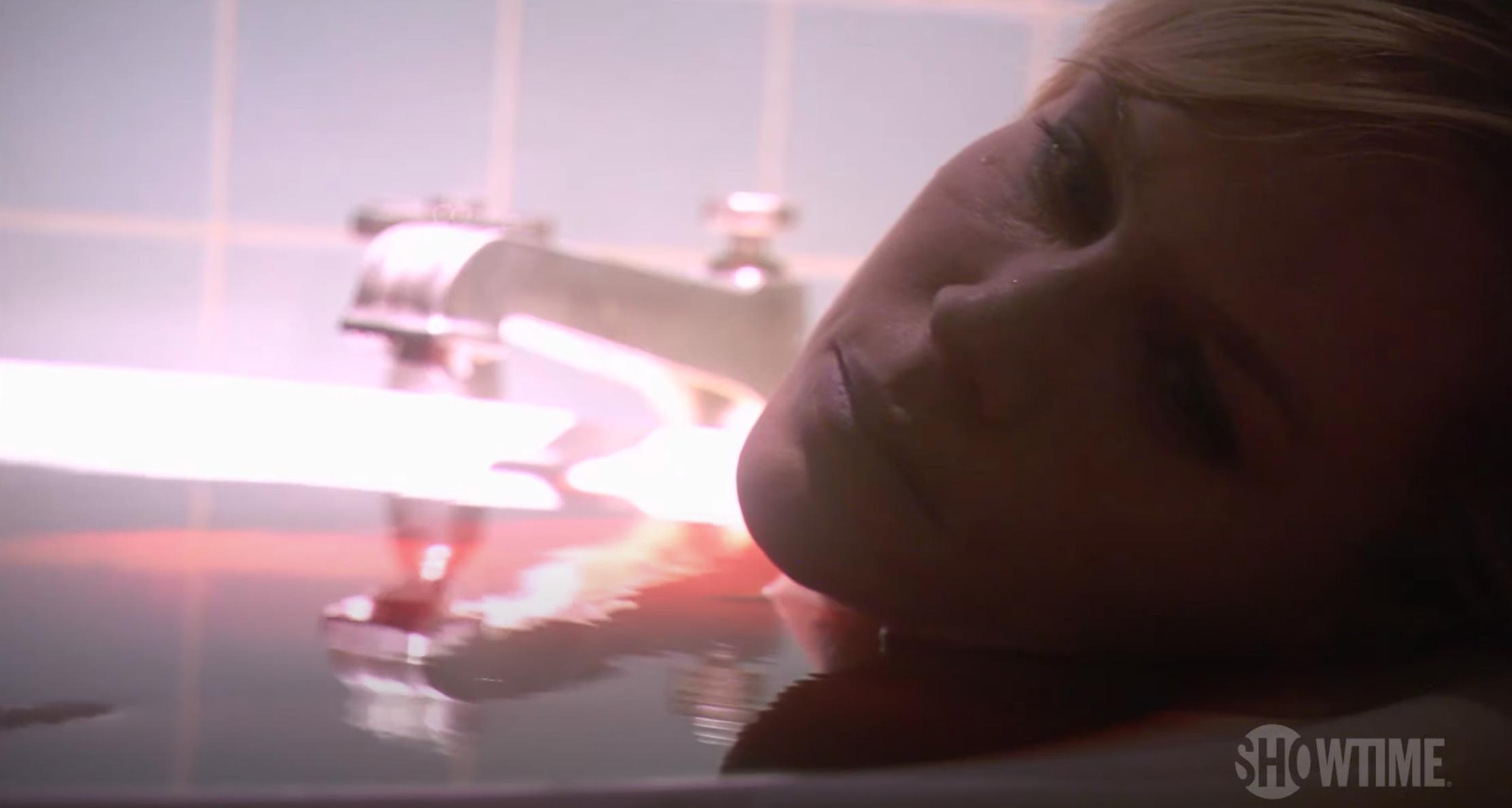 A woman lies in a tub full of blood