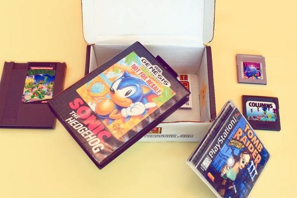 a box with tomb raider for playstation, sonic for genesis, and other retro games