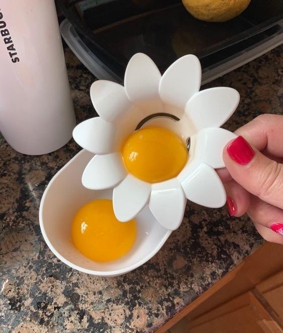 a reviewer using the white daisy-shaped tool to separate egg yolks from whites