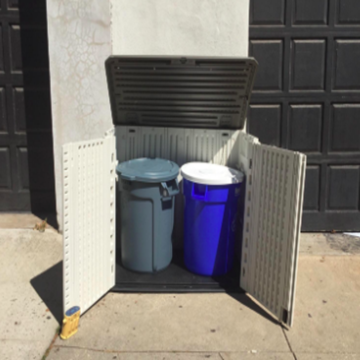 open shed to reveal a trash can and recycling bin 