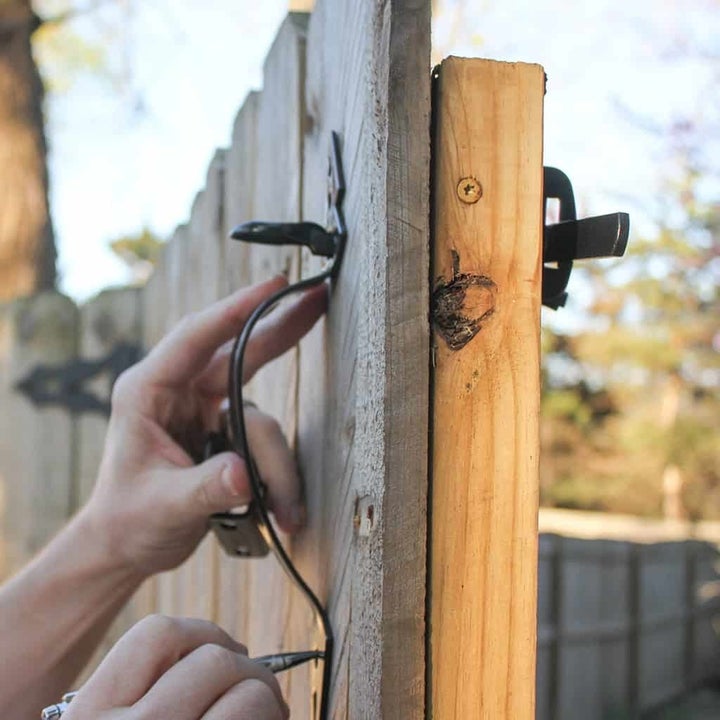 person putting a gate pull on a yard gate door