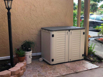 reviewer pic of shed with a lid and to front doors on a patio 