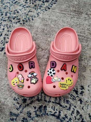 a reviewer's pink crocs covered in jibbitz