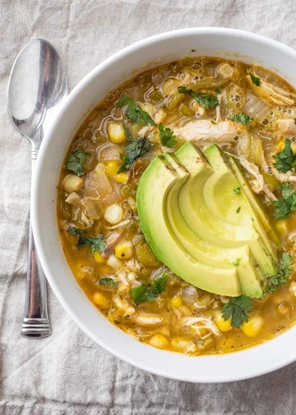 Green Chicken Chili in a bowl with avocado slices on top