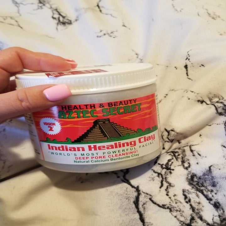 a hand holding the jar of product 