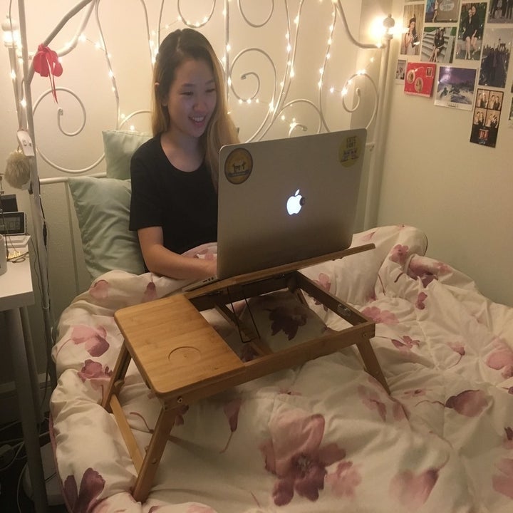 former BuzzFeed Editor Sarah Han working from bed with laptop tray 