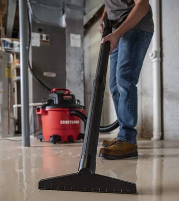 A idiosyncratic utilizing a wet-dry vacuum to woody with h2o successful a basement