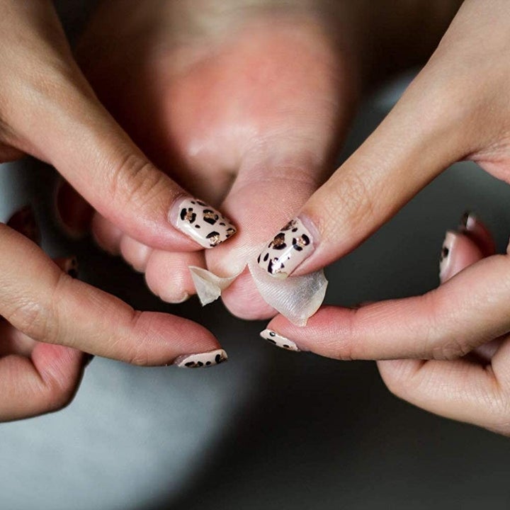 A person peeling dead skin off their toe