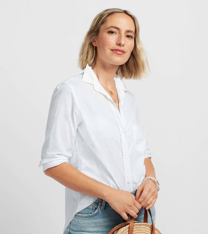 Model wearing white shirt with sleeves rolled up