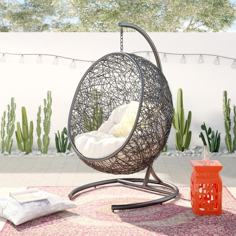 free-floating wicker chair with white cushion and metal stand