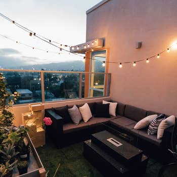 A patio at dusk with round string lights on a black wire