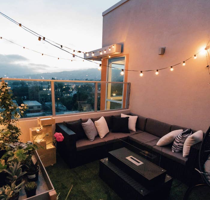 A patio at dusk with round string lights on a black wire 