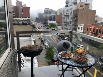 A reviewer shows the same grill on their apartment balcony, which has a tiny seating area