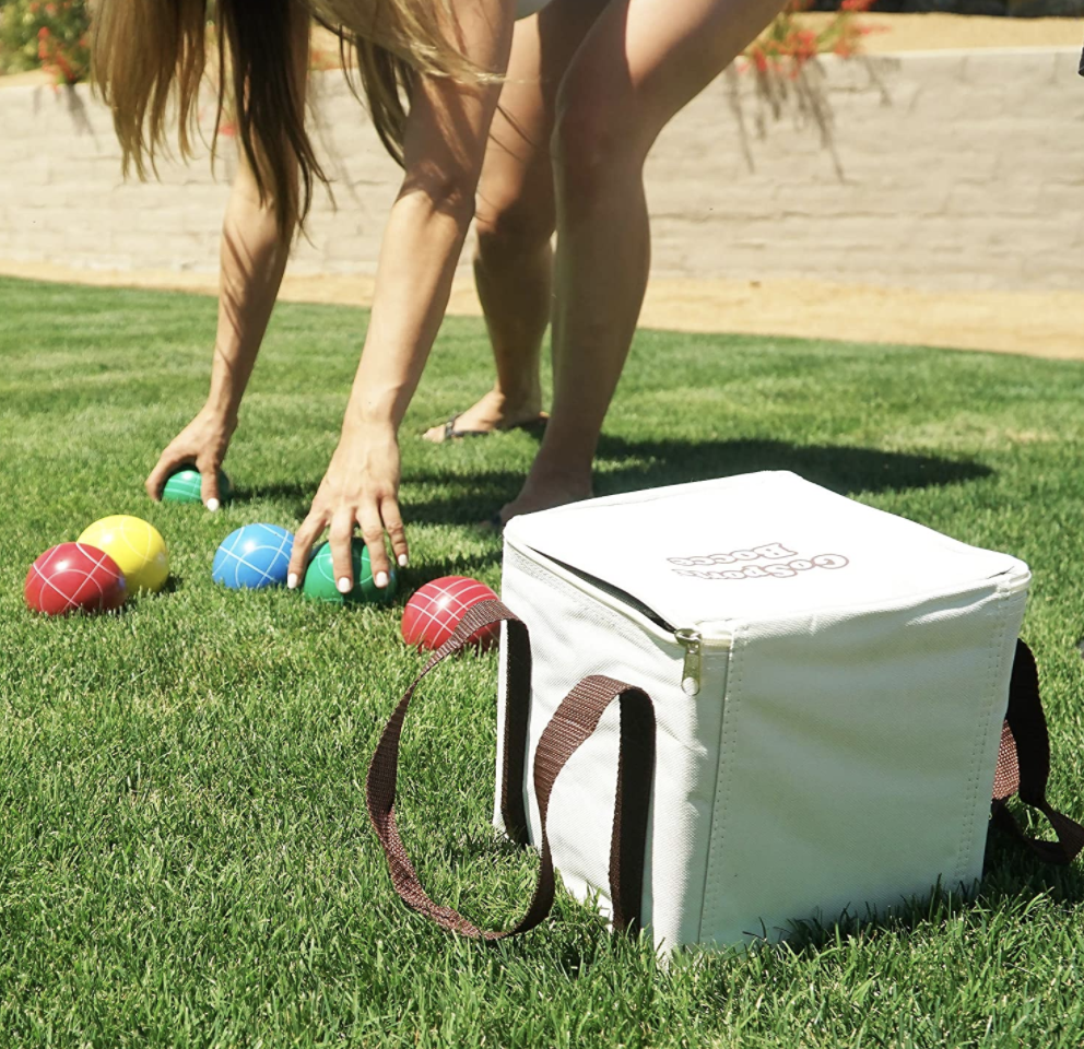 A model plays with a colorful bocce set in their yard