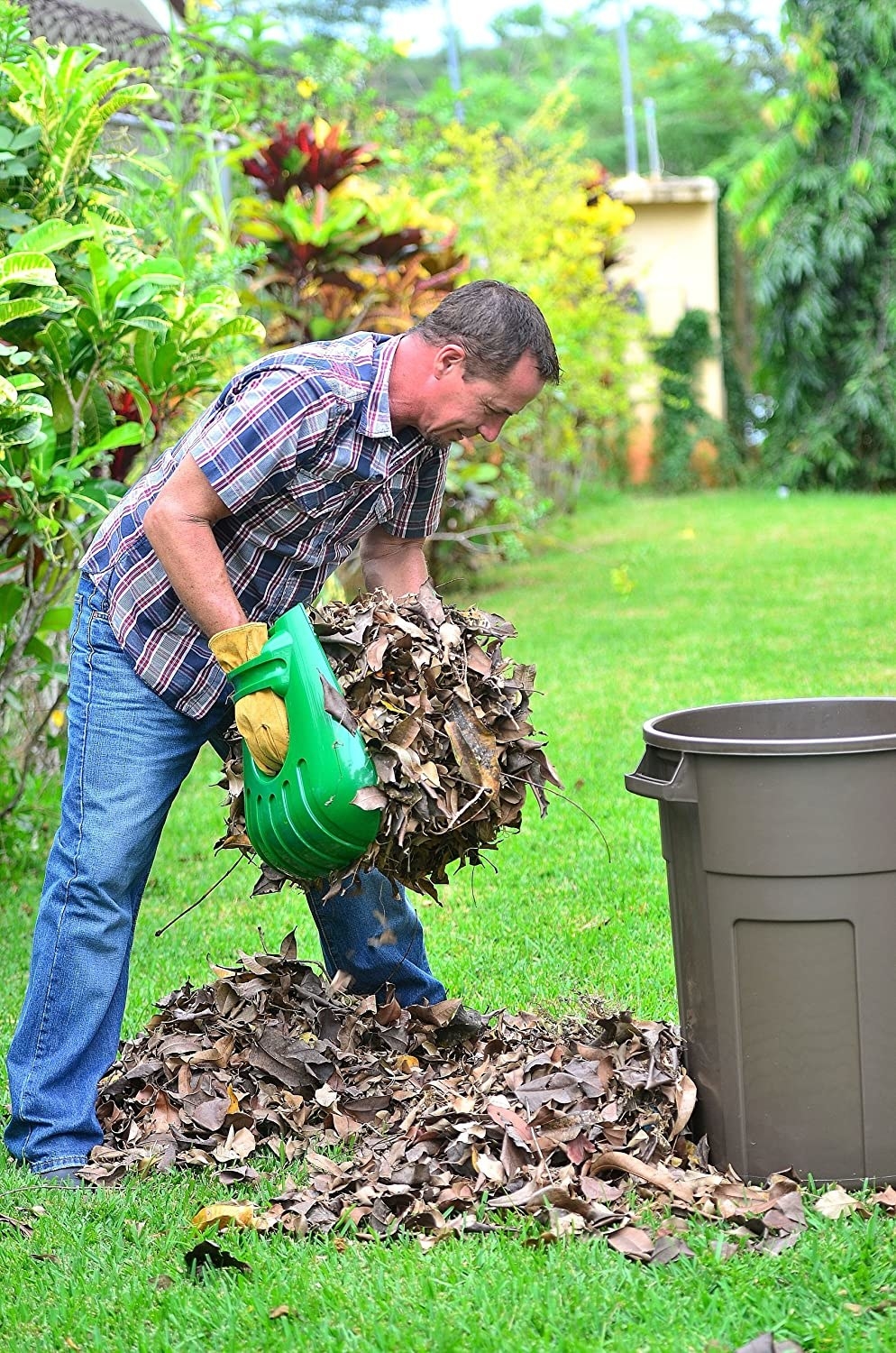 Model holding the scoops and transferring a large handful of leaves into a trash can