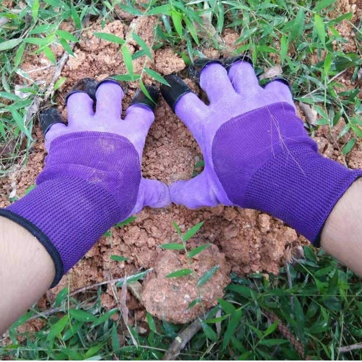 Hands wearing the claw gloves and digging deep into a pile of dirt
