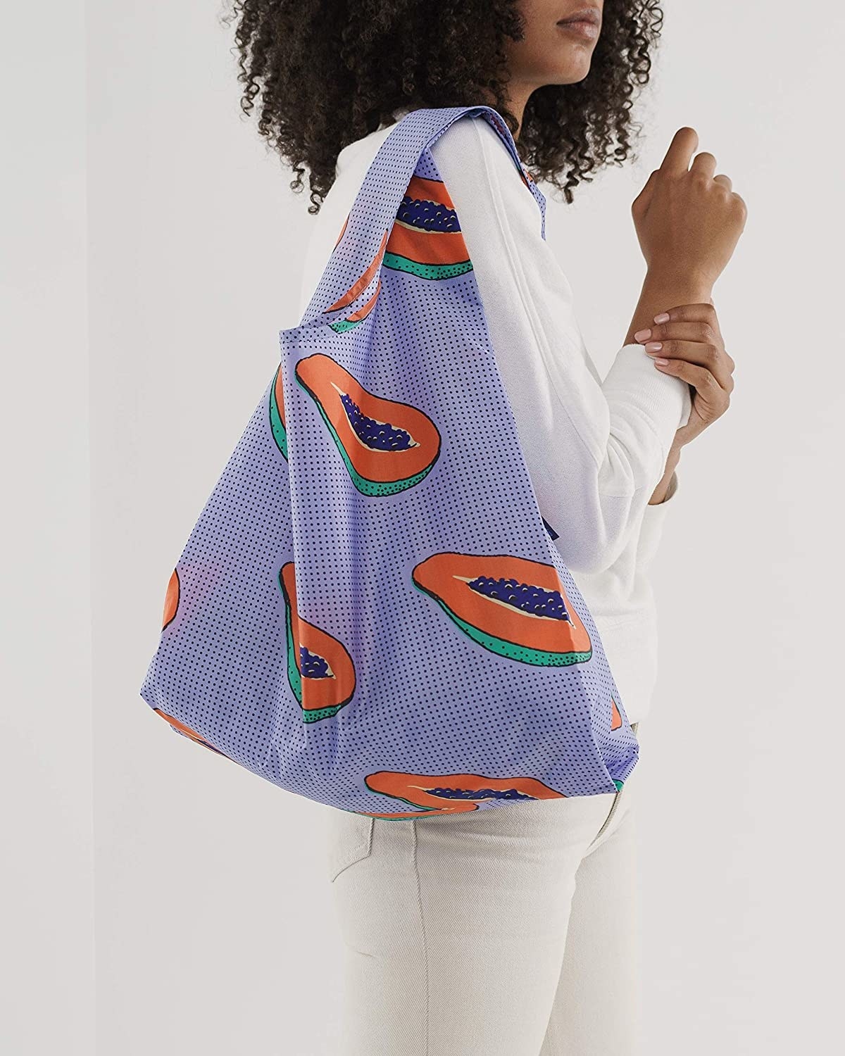 A model wearing the reusable bag on their shoulder