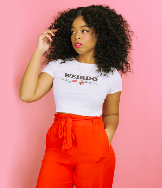 A model wearing the white short-sleeve crop top, which is printed with the word &quot;WEIRDO&quot; with two roses underneath