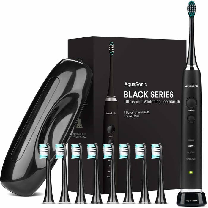 Packaging and contents of an electric toothbrush set including handle, eight heads, and case all in black