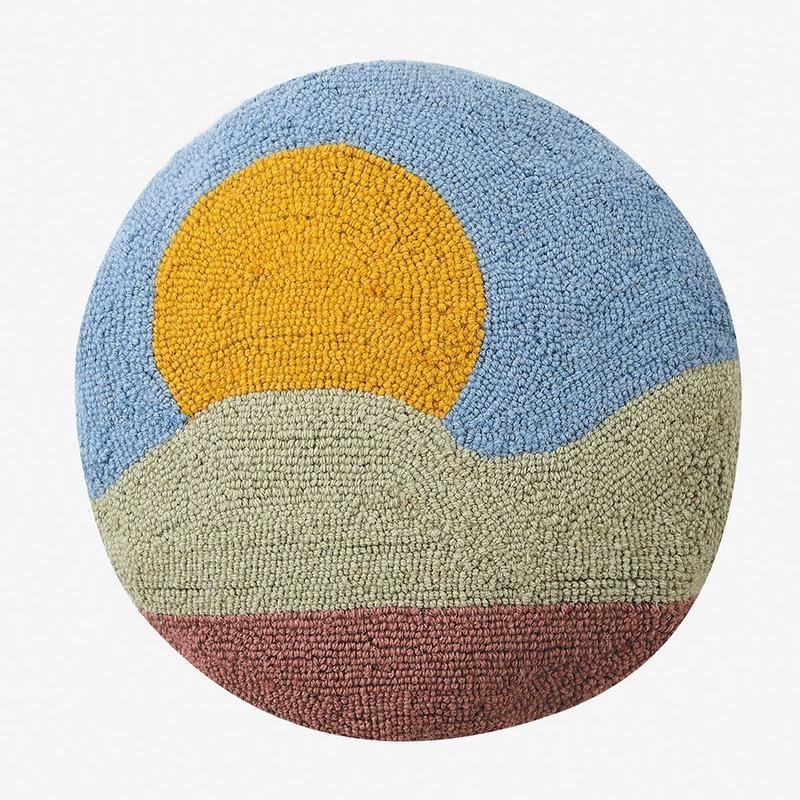 round hook pillow with a minimalist sun and mountain scene