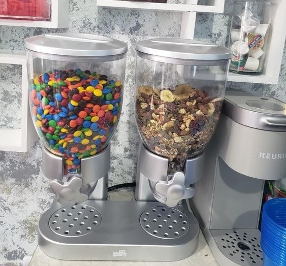 Reviewer&#x27;s picture of the food dispenser with M&amp;amp;M&#x27;s and granola 