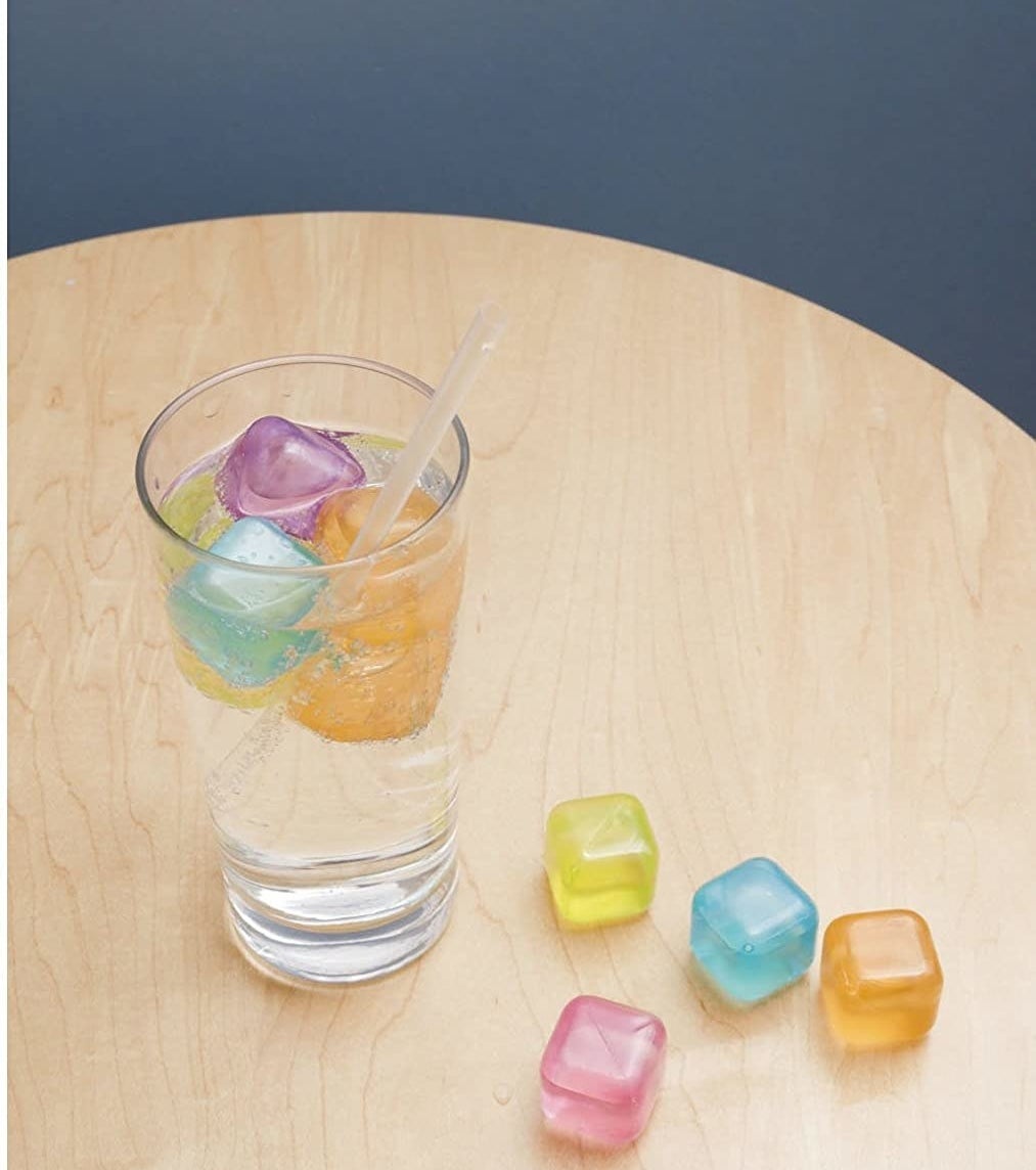 A glass is perched on a table, filled with several silicone ice cubes