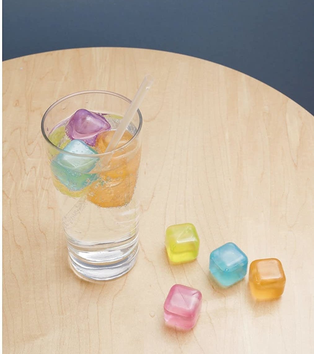 A glass is perched on a table, filled with several silicone ice cubes