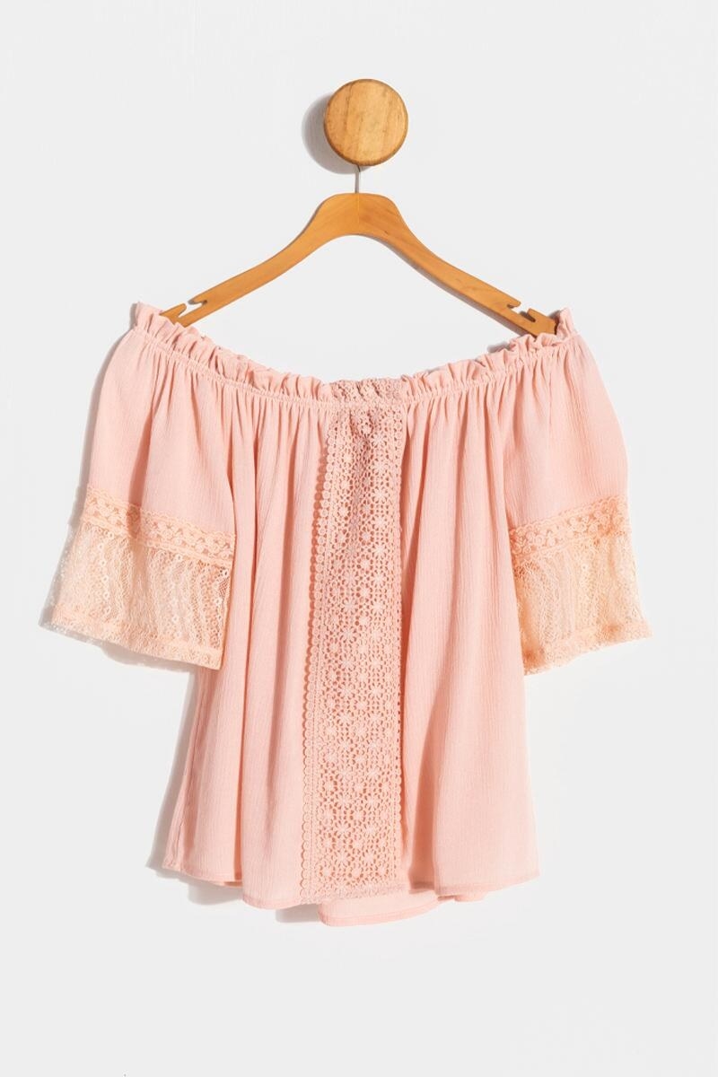 The peachy pink blouse, which has crochet details down the center and on the sleeves