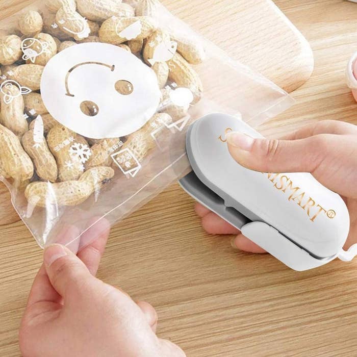 A person uses the bag sealer to close a bag full of peanuts