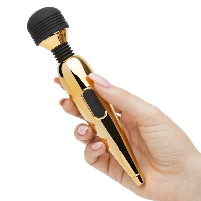 hand holding gold vibrator with vibrating head