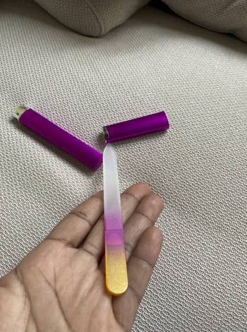 Reviewer's hand holding a glass file. It has an ombre color design that goes from yellow to purple to plain, clear glass.