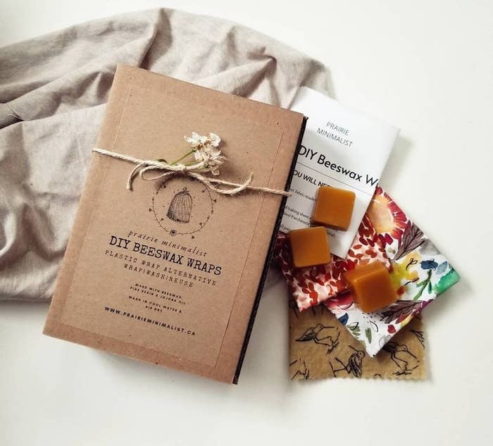 A product shot of printed packaging wrapped in twine with three fabric scraps and three cubes of wax 