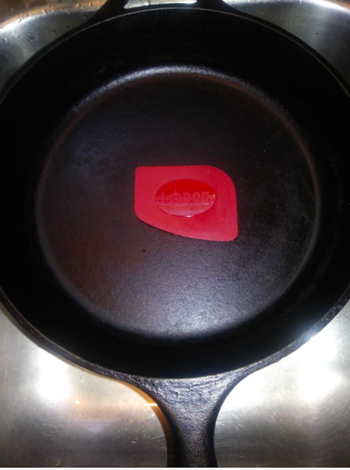The same skillet totally clean, with the slightly angled red scraper in the middle