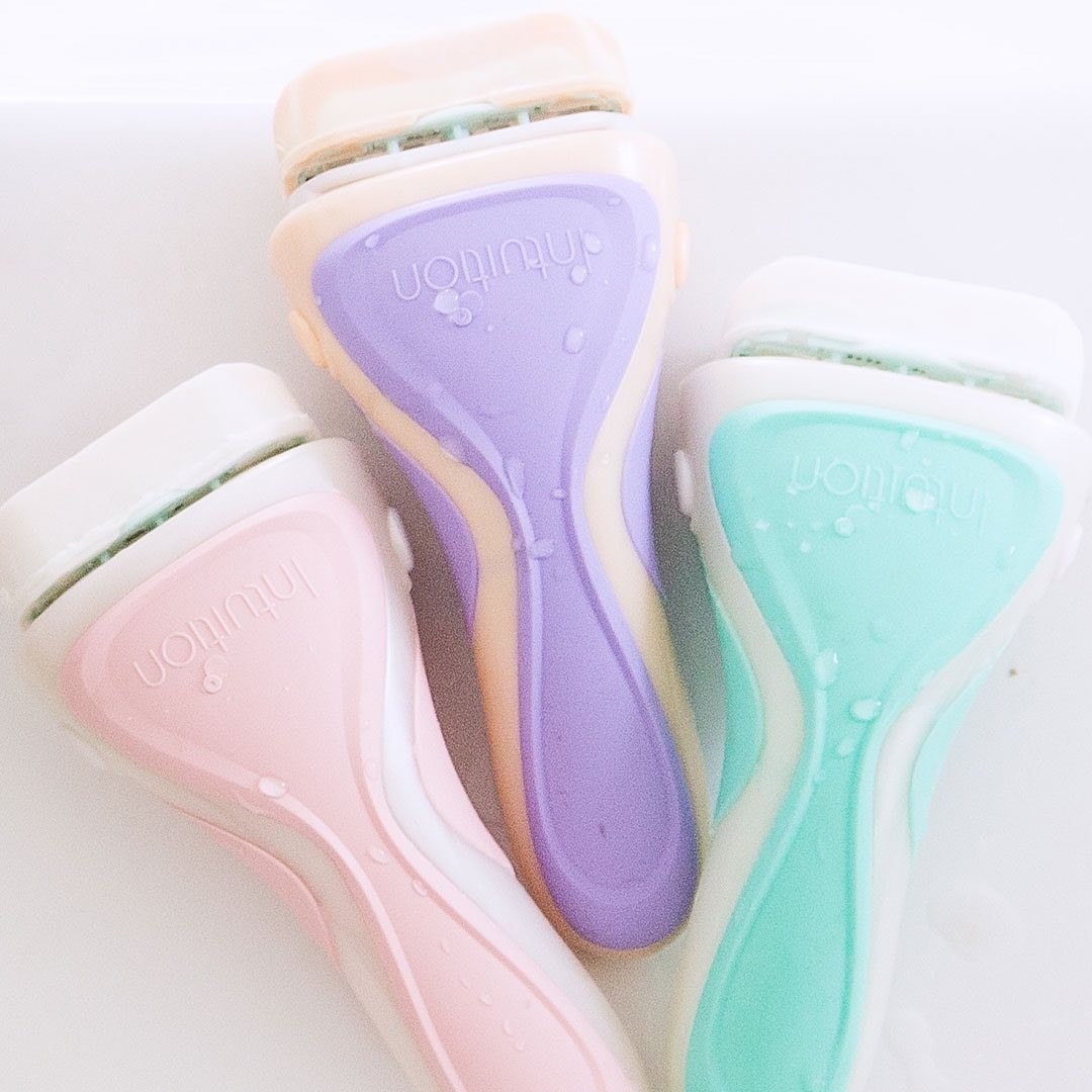 one pastel pink, one purple, and one blue razor