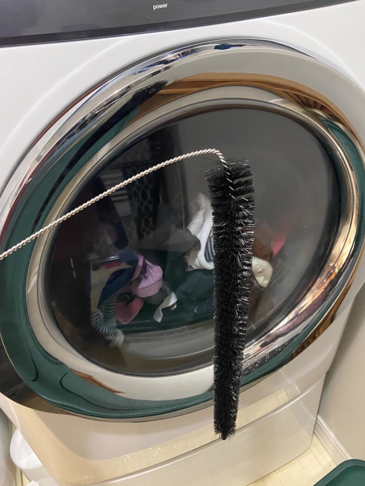 A reviewer holding the curved dryer brush