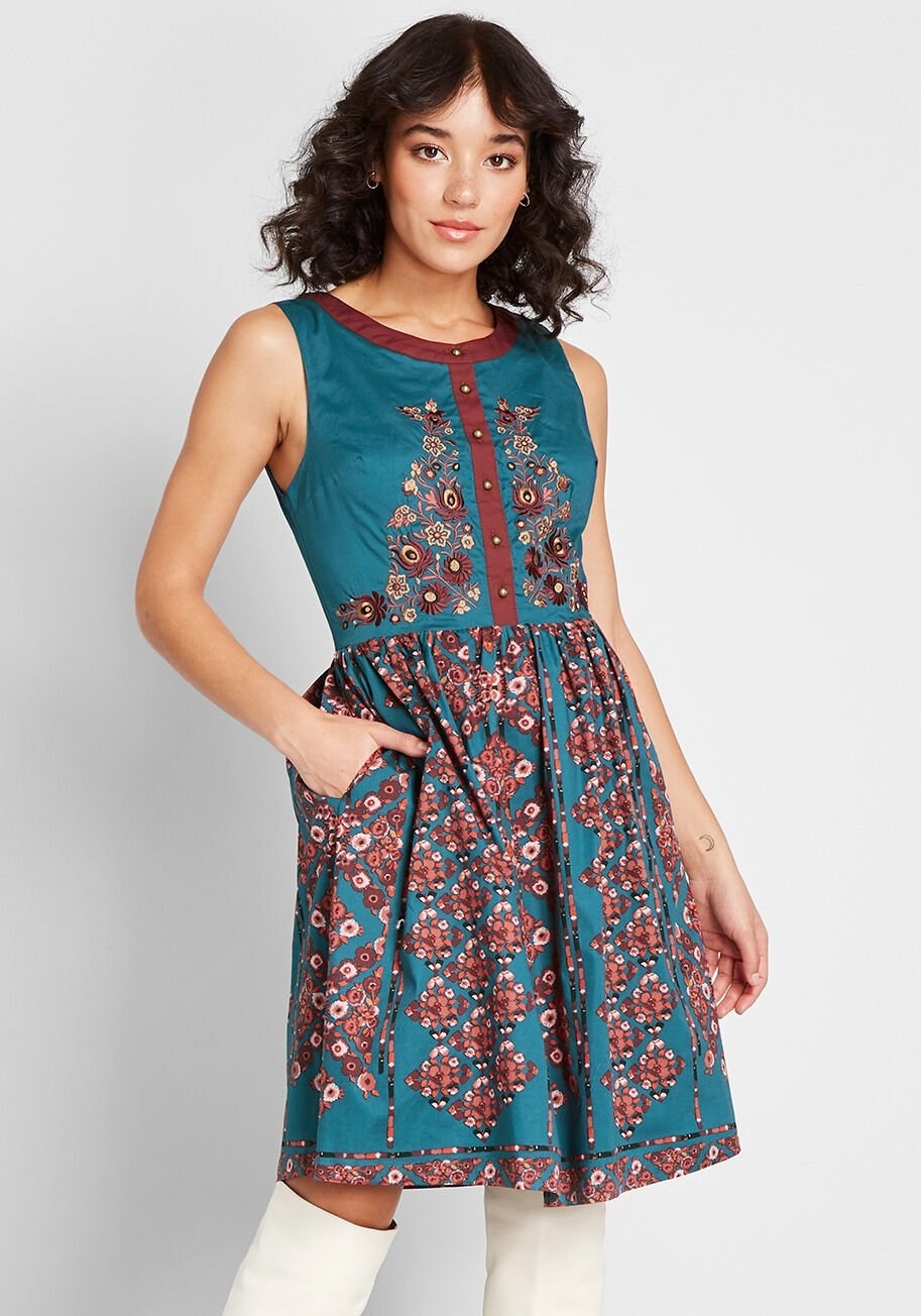 Model with their hand in the pocket wearing the dress that comes down to the knees