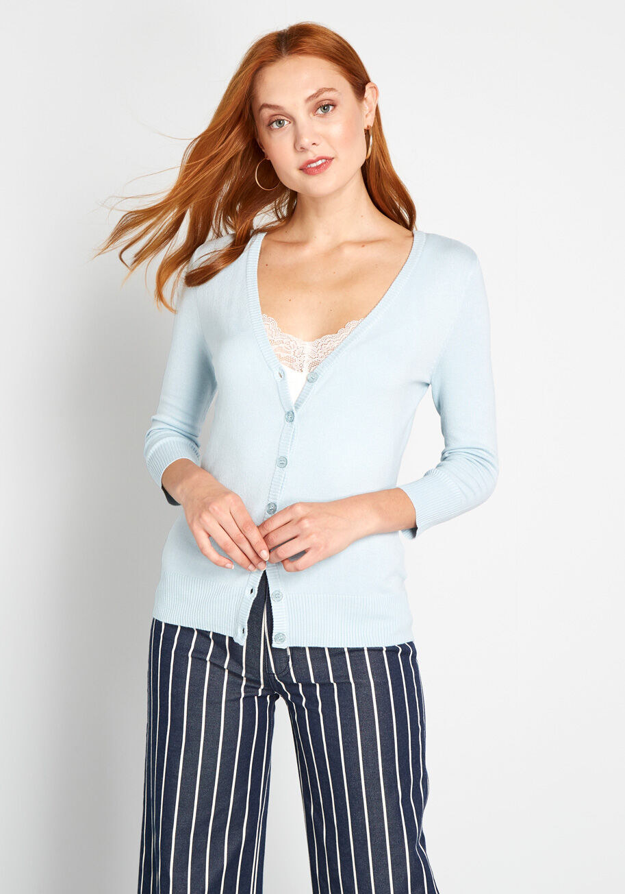 Model wearing light blue cardigan buttoned up with a lace tank underneath that peeks out