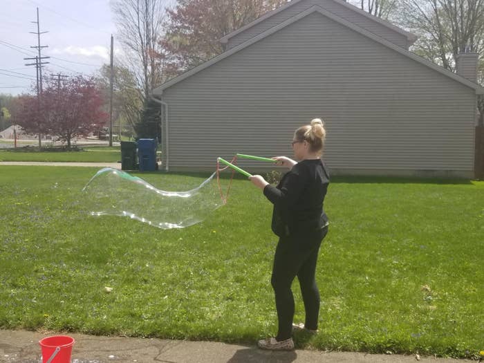 A reviewer using the kit to make a giant, long bubble