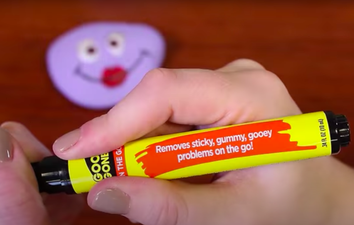 A person holding a Goo Gone pen